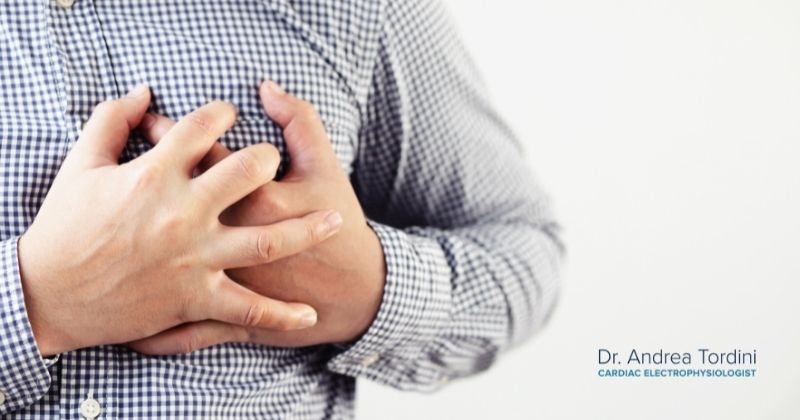 Man clutches his chest as he wonders if his symptoms are a heart attack, but these symptoms could be Afib according to electrophysiologist Dr. Andrea Tordini.
