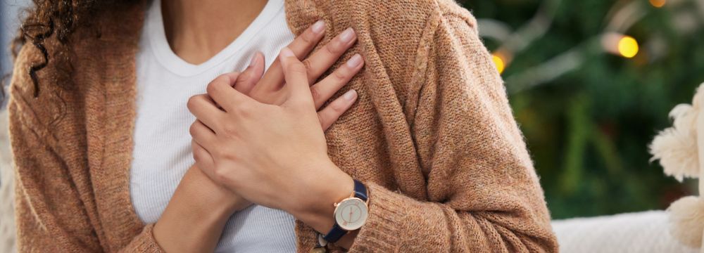 Woman holding top of chest with hand