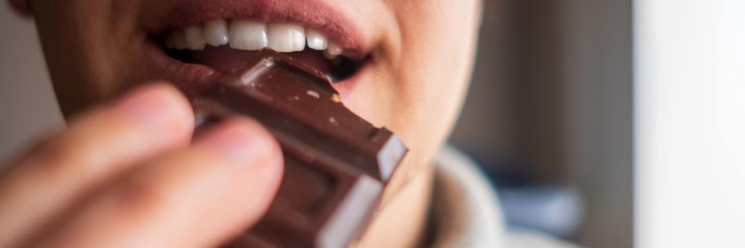 Man biting into chocolate bar