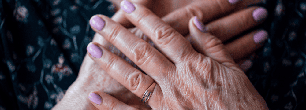 Woman covering heart with overlapping hands 